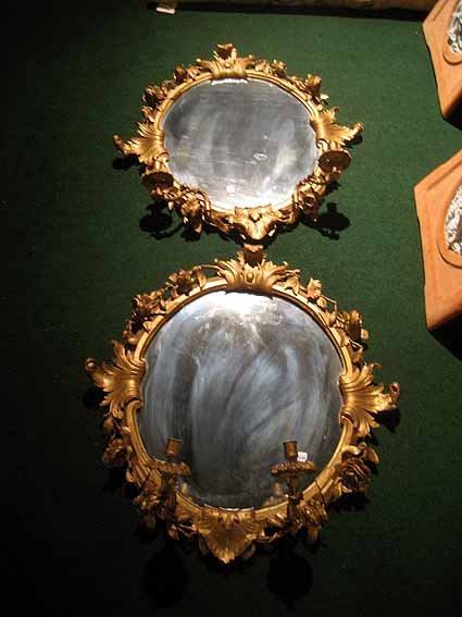 Pair gilded wood and gesso mirrors w/2 candle holders: Pair carved gilded wood and gesso mirrors with two candleholders and each base - slight damage to carving on one mirror, 30" high, 30" wide.