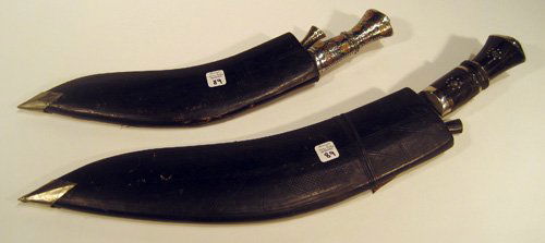 Two Ornate Machete Type Knives in leather sheaths: Two ornate Machete type knives in leather sheaths: 22" and 17" long.