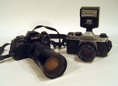 Two vintage 35mm cameras: Pentax & Minolta: Two vintage 35mm cameras: Asahi Pentax K1000 with flash unit and Minolta X-700.