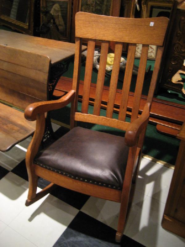 Oak Mission style rocking arm chair with brown leather: Oak Mission style rocking arm chair with brown leather upholstered seat.