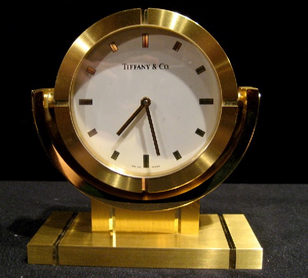 Tiffany & Co. Brass Framed Desk Clock: Tiffany & Co. brass framed desk clock on swivel stand, 4.75" high overall, 4" wide - in working condition.