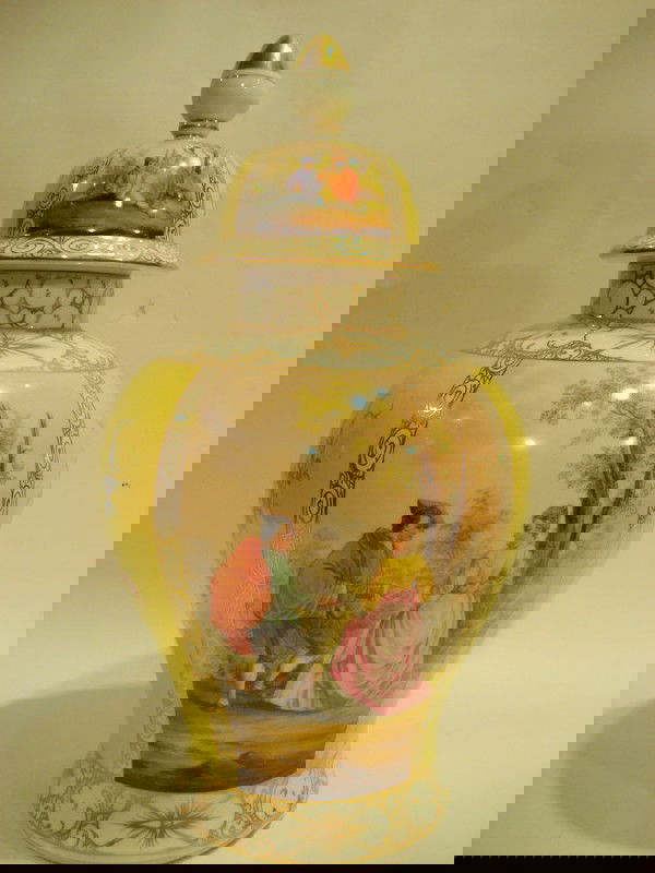 Hand painted porcelain lidded urn: Hand painted porcelain lidded urn decorated with panels of flowers and figures, 21" high - repaired at rim.