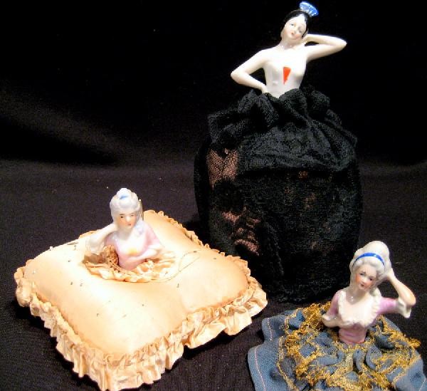 3 Porcelain Half Dolls: Three porcelain half dolls with pin cushion bases ranging from 3.5" to 8" high overall. Age: vintage.