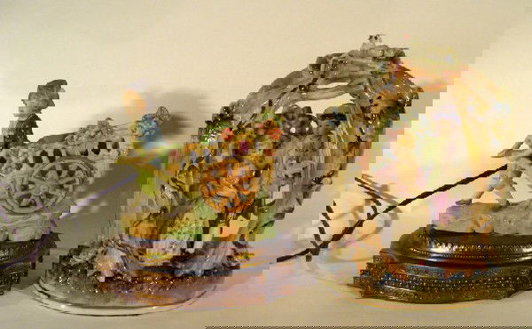 2 Porcelain Figural Dresser Lamps: Two porcelain figural dresser lamps: boy pulling cart, 8" high and seated man and woman, 9" high. Age: vintage