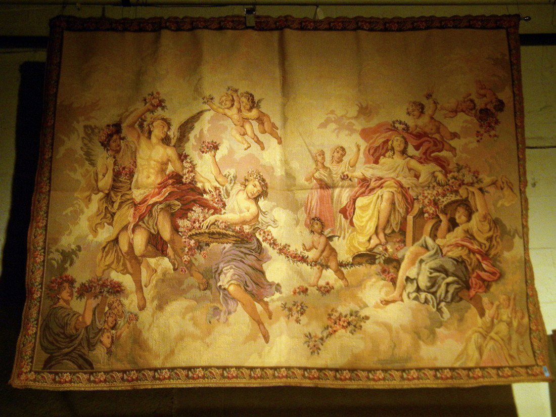 French Needlepoint Tapestry: French needlepoint tapestry decorated with angels and cherubs holding flowers framed by needlepoint flower and scroll border, 50" high, 70" wide. Made in France stitched into back.