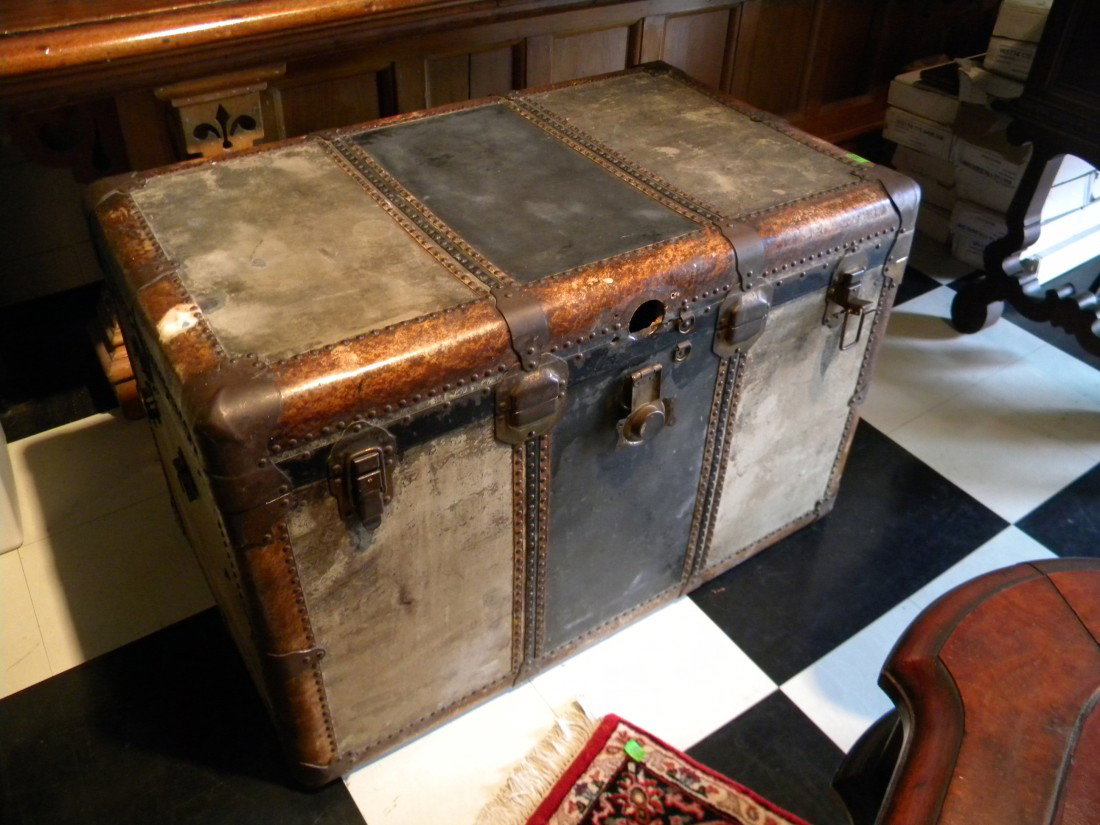Black steamer trunk with brass hardware & brass button: Black steamer trunk with brass hardware and brass buttons around trim, 26" high, 40" wide, 24" deep - lock damaged, missing leather handles on sides, overall surface damage