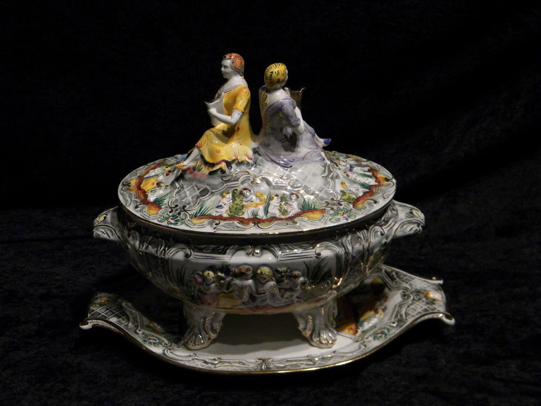 Capodimonte Style Glazed Porcelain Lidded Footed Tureen: Capodimonte style glazed porcelain lidded and footed tureen decorated with nude scenes and cherubs throughout, man and woman playing harp on lid, on matching under plate, marked "Pereiras Valado Made
