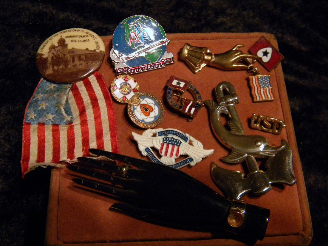 Lot of 11 miscellaneous pins: Lot of 11 miscellaneous pins including: figural hand holding American flag, National Auxiliary round pin, American Airlines 1997 globe pin, Sterling silver figural dolphin with boat anchor pin, etc.