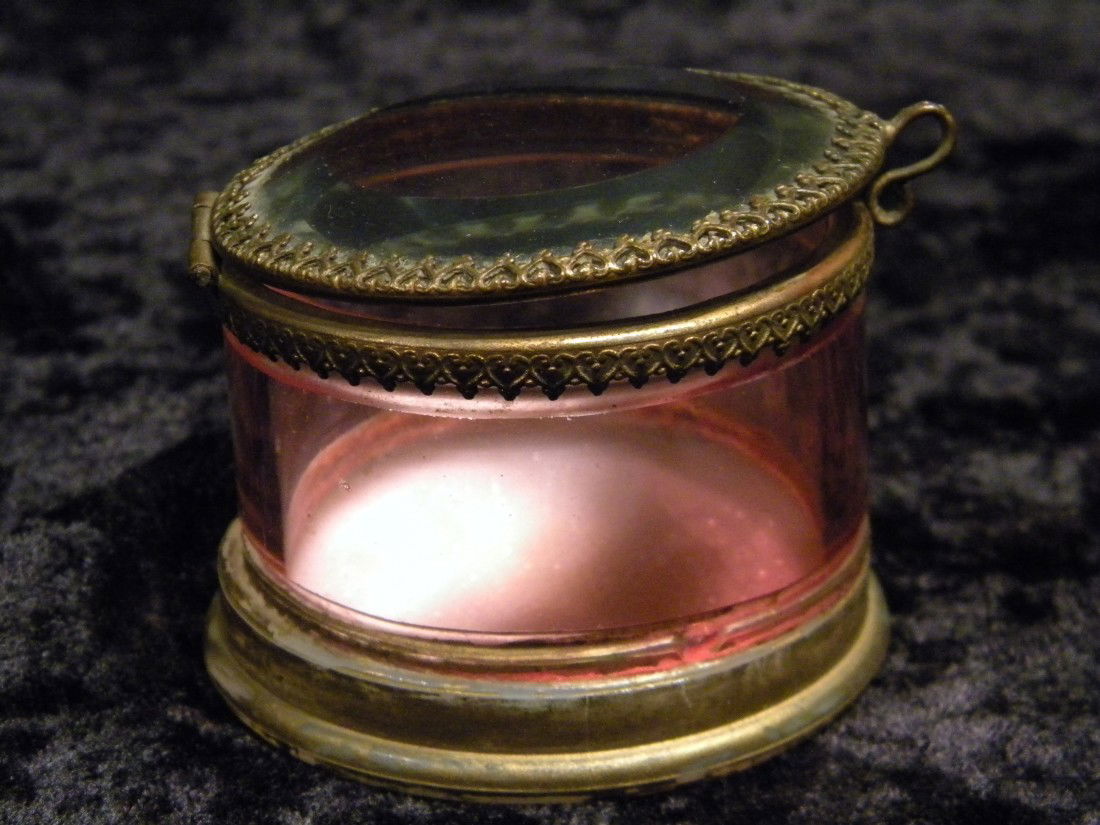 Round Cranberry Glass Hinged Lidded Patch Box: Round cranberry glass hinged lidded patch box with glass lid, metal frame, 2" high, 2.5" diameter.