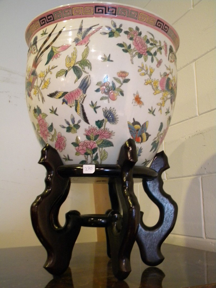 White Ceramic Fish Bowl on Wooden Stand: White Ceramic fish bowl with multi-colored floral, bird and butterfly design on outside and orange Coi painted inside, on 5-footed wooden base, marked "Made in China. For decorative purposes only", 20
