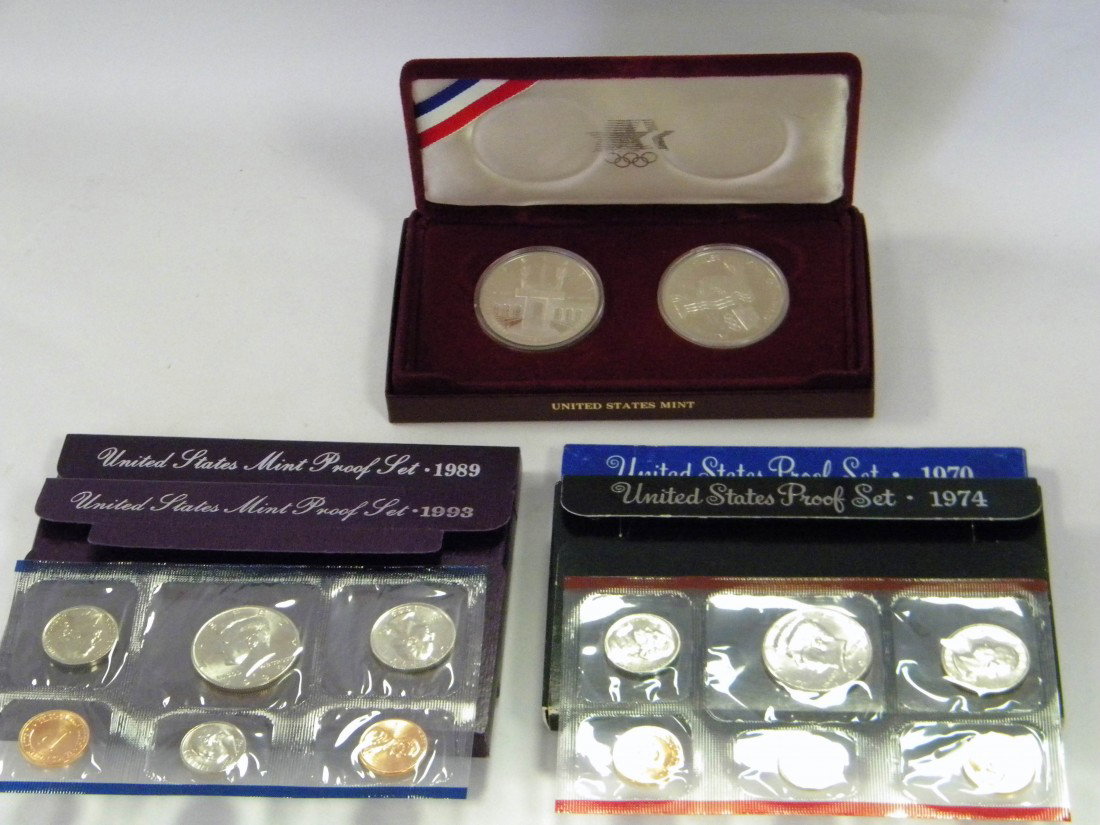 6 U.S. Mint Proof Sets & 2 Olympiad Commemoratives: 6 U.S. Mint Proof Sets: 1970, 1974, 1989, two 1992, 1993 and U.S. Mint Set of 2 Commemorative Los Angeles Olympiad Coins, 53.6g - All in original display boxes and packaging.