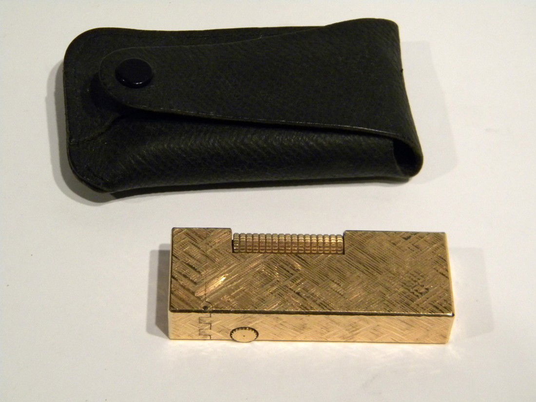 Dunhill Flip Top Lighter: Dunhill Flip Top Lighter marked "patented US RE24163, Made in Switzerland" with gold colored checkered pattern on outer case, 2.5" high, with original black leather snap travel case.