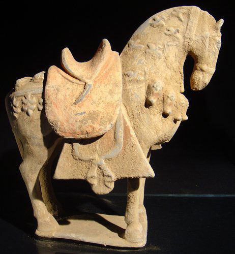 A PAINTED WELL-MODELLED POTTERY FIGURE OF A CAPARIS: Well modelled in a powerful stance and with sensitively detailed face, the rich trappings including a foliate-decorated bridle, a rope tied around the top of the arched neck, large tassels on the ches