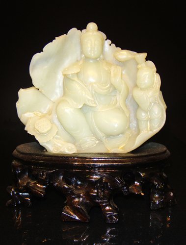 A yellow jade figure of Guanyin19th century: shown seated in royal ease upon a lotu leaf base her right hand holding a ruyi scepter and a boy stand in her left. 4 3/4''inH