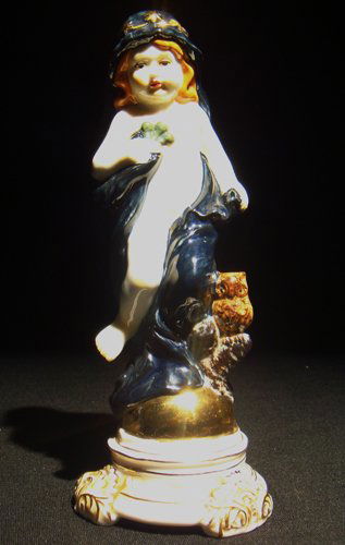 A Meissen porcelain allegorical figure of 'Night: A Meissen porcelain allegorical figure of 'Night' depicted as a putto draped in blue, an owl perched to his side. Crossed swords mark in blue under glaze, incised "J5", and "10" . 8"H, Circa - 1900.