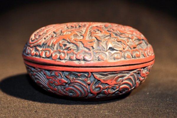 A SMALL CARVED CINNABAR LACQUER PHOENIX BOX (QING: A SMALL CARVED CINNABAR LACQUER PHOENIX BOX QING DYNASTY. FOUR CHARACTER MARK. 4'' DIAM 2''H
