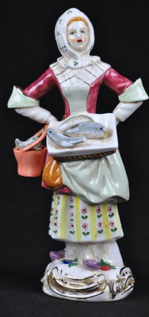 A MEISSEN PORCELAIN FIGURE OF A FAMALE FISHMONGER.: A MEISSEN PORCELAIN FIGURE OF A FAMALE FISHMONGER.(circa-1924-1934).a tray of fish at her hip, a basket of fish in hand. Cross swords mark,''132''. 8''H