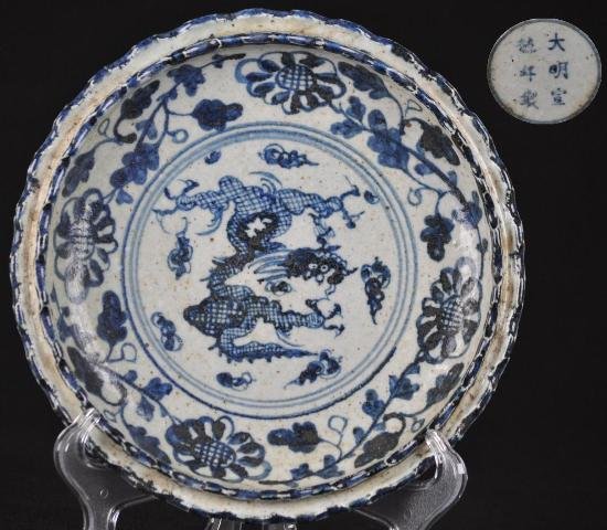 A BLUE AND WHITE DISH.(MARK AND PERIOD OF XUAN DE): A blue and white dish its interior decorated with a dragon chasing a pearl and the exterior surrounded by flowers.(Mark And Period Of Xuan De) 8 3/4 diam