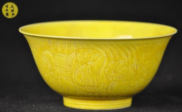 A YELLOW GROUND ANHUA bowl.(MARK AND PERIOD OF HON: a yellow ground anhua bowl with fish and floral design ( MARK AND PERIOD OF HONGZHI) 2 3/4''H 5 3/4''DIAM