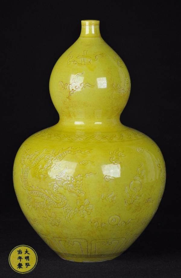 A YELLOW-GROUND ANHUA DOUBLE GOURD(MARK AND THE PE: The body is carved with two dragons chasing a pearl. 15" high