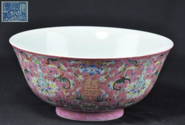 A PINK GROUND FAMILE-ROSE BOWL. (DAOGUANG): Decorated with bats and lotus scrolls and double happiness characters, six character marks on the base. 3-3/4'' x 8-1/4'' diam. (Mark and period of Daoguang.)