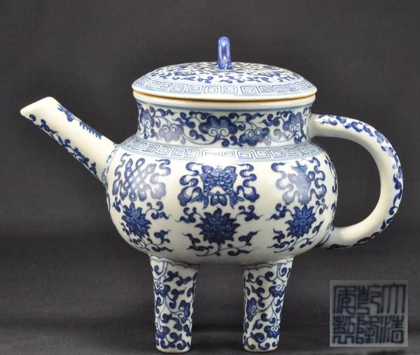 A BLUE AND WHITE EWER AND COVER, HE (QIANLONG): The ewer with globular body raised on four tapering columnar supports painted with lingzhi scroll and painted around the sides with the Eight Buddhist Emblems (bajixiang), six positioned above lotus s