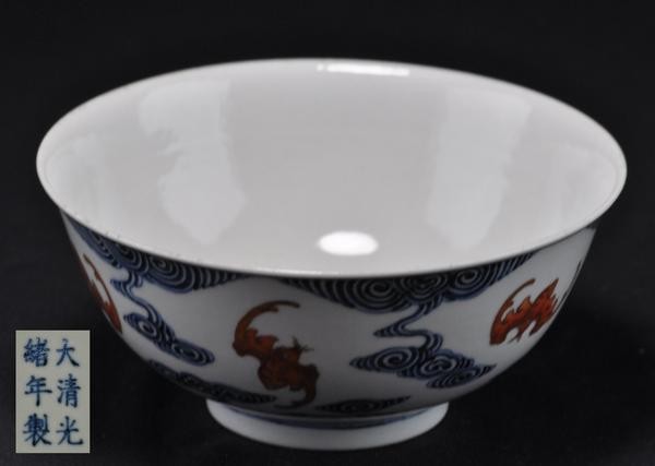 A BLUE AND WHITE IRON RED BOWL.: Exterior and interior painted with bats flying on the clouds six character marks on the base. 2-1/2'' Tall x 1-1/2'' diam. (Mark and period of Guangxu.)