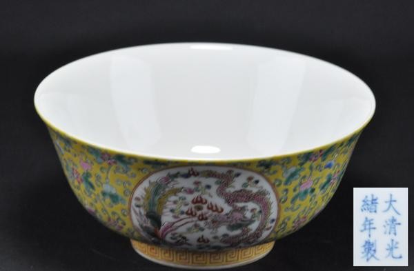 A YELLOW GROUND FAMILLE-ROSE BOWL. (GUANGXU): The interior painted with five bats the exterior is decorated with dragons,phoenixes, and florals six character marks on the base. 3-3/4'' x 8'' diam. (Mark and period of Guangxu.)