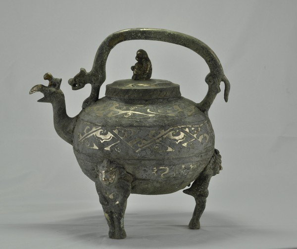 A BRONZE SILVER INLAID TEAPOT.(HAN DYNASTY): Supported with three mask legs, rooster head and monkey on top of the cover. 10-1/2''H