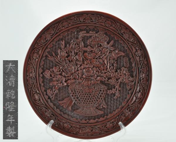 A CINNABAR LACQUER DISH.(QING DYNASTY): Interior carved with vase and floral design six character marks on the base. 11-1/2'' diam