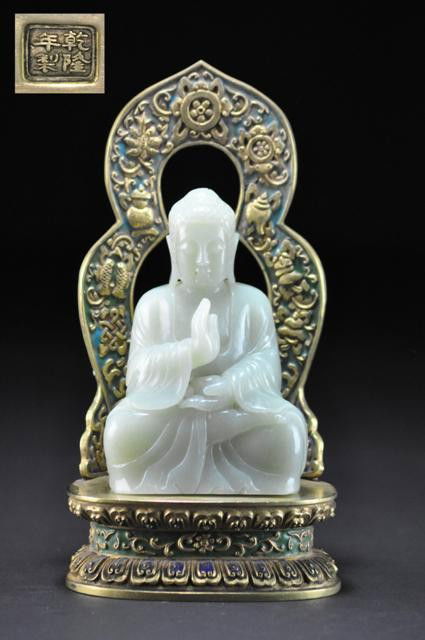 A RARE WHITE JADE FIGURE OF BUDDHA .18TH CENTURY: Shown seated in dhyanasana , dressed in long, flowing robes left open at the chest and a waist-tied dhoti, the serene face with downcast expression beneath a large, protruding urna set amidst the whor