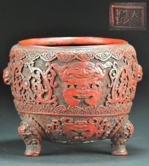 A CINNABAR LACQUER TRIPOD CENSER.( 18 CENTURY): Support with three legs and with two lions head handel a six character mark on base. 7''x8 3/4''. PROVENANCE: FROM STATEN ISLANDS PRIVATE COLLECTION.