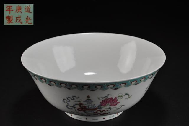 A FAMILLE ROSE BOWL. (DAOGUANG MARKS IN IRON-RED : The exterior decorated with the Eight Buddhist Emblems (bajixiang) arranged in four groups between ruyi bands.six character mark on base. 4 1/2''x9 1/4''.