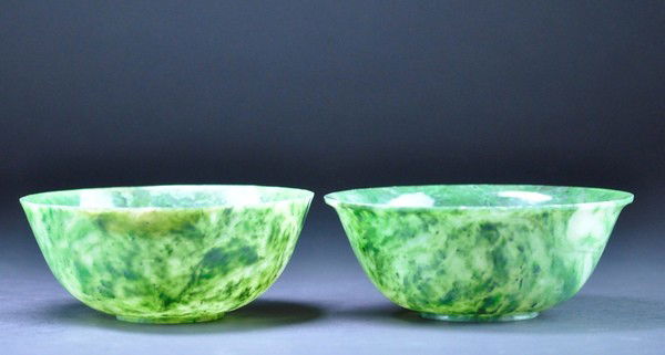A PAIR OF SPINACH GREEN JADE BOWLS.: A PAIR OF SPINACH GREEN JADE BOWLS. Each with rounded sides flaring from the foot ring towards the rim, the semi-translucent stone densely mottled and shading from white to moss green.6 1/2'' Diam.