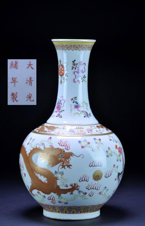 A FAMILLE-ROSE BOTTLE VASE. (MARK AND PERIOD OF G: A FAMILLE-ROSE BOTTLE VASE. (MARK AND PERIOD OF GUANGXU) decorated with a pair of dragons confronted on a flaming pearl amidst flames and clouds, the neck with a bajixiang.six character mark on base. 