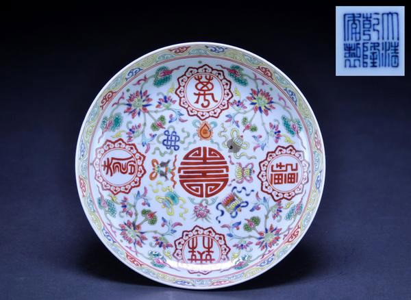 A FAMILLE- ROSE DISH. (MARK OF QIANLONG LATE 19 C: A FAMILLE- ROSE DISH. (MARK OF QIANLONG LATE 19 CENYURY) the interior painted with BAJIXIANG symbol surrounding shou character and exterior design with bats six character mark on base. 1 1/2''x7 1/2''