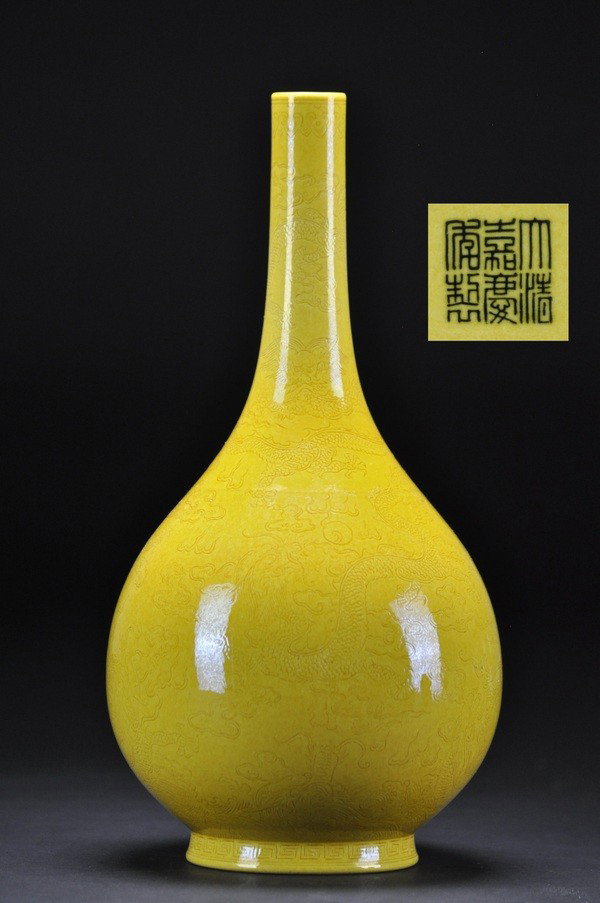 A YELLOW-GROUND INCISED BOTTLE VASE .(MARK AND PER: - A YELLOW-GROUND INCISED BOTTLE VASE .(MARK AND PERIOD OF JIAQING) The ovoid body and neck incised with a large five-clawed dragon racing amidst clouds and flames in pursuit of a flaming pearl above 