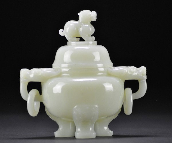 A CARVED CHINESE JADE CENSER AND COVER.: - A CARVED CHINESE JADE CENSER AND COVER. The globular body raised on three narrow curved legs, with a pair of horned dragon-mask handles at the edge of the flat shoulder suspending loose rings, the p