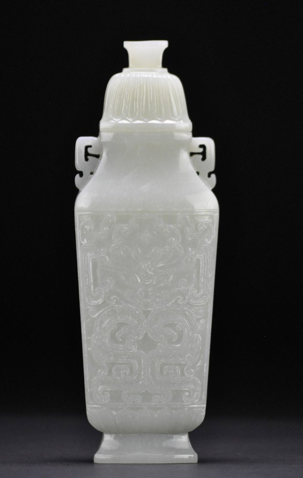 A WHITE JADE SQUARE VASE .: - A WHITE JADE SQUARE VASE . Of gently tapering square form on a slightly spreading foot, the waisted neck with loop handles, decorated with with a taotie mask.21cm H.
