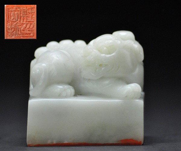 A SOAPSTONE LION SEAL.(QING DYNASTY): - A SOAPSTONE LION SEAL.(QING DYNASTY) well carved with a recumbent lion resting on one front paw, the other outstretched as it turns its head to the side, the details of the long mane and tail finely