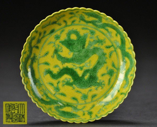 A YELLOW AND GREEN-GLAZED SCALLOP-RIMMED DISH (QIA: - A YELLOW AND GREEN-GLAZED SCALLOP-RIMMED DISH (QIANLONG SIX-CHARACTER MARK IN UNDERGLAZE BLUE ) Decorated on the interior with a dragon roundel below two green dragons chasing flaming pearls in the