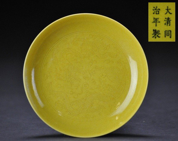 A YELLOW-GROUND ANHUA DISH.(MARK AND PERIOD OF TON: - A YELLOW-GROUND ANHUA DISH.(MARK AND PERIOD OF TONGZHI) incised five-clawed dragons chasing a flaming pearl amongst fire scrolls.TongZhi mark on base.2.5x14cm