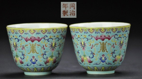 A PAIR OF FAMILLE-ROSE CUPS.(MARK AND PERIOD OF TO: - A PAIR OF FAMILLE-ROSE CUPS.(MARK AND PERIOD OF TONGZHI) Supported on conforming foot rims and with curved sides, each enamelled with flowering lotuses bats and Shou .7x9 cm.