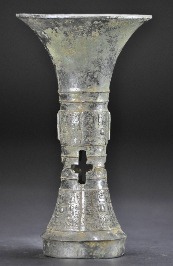 A BRONZE RITUAL WINE VESSEL, GU (SHANG DYNASTY): - A BRONZE RITUAL WINE VESSEL, GU (SHANG DYNASTY) With plain trumpet-form neck above a pair of bow-string bands, the rounded mid-section flat-cast with a band of two pairs of dragons with rounded eyes