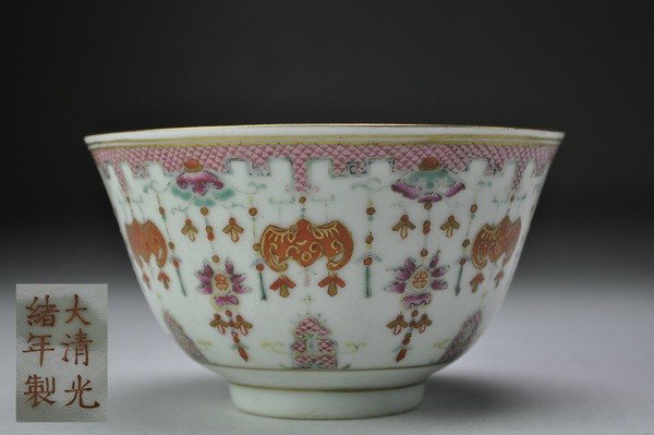 A FAMILLE-ROSE BOWL.(MARK AND PERIOD OF GUANGXU): - A FAMILLE-ROSE BOWL.(MARK AND PERIOD OF GUANGXU) The deep sides rising to a flaring rim decorated on the exterior with iron-red bats suspending wan emblems and surrounded by a dense ground of foliat