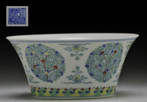 A DOUCAI BOWL. (MARK AND PERIOD OF QIANLONG): with flared, outward-curved sides painted with five roundels of stylized flowering or fruiting trees separated by pomegranate sprays above a band of overlapping petals.2 3/4''H 6 Diam