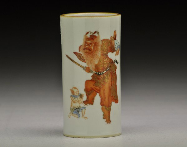 A FAMILLE-ROSE BRUSHPOT.(19 CENTURY): painted with a scene of Zhong Gui in a landscape clutching his sword in his left hand, his right raised as he looks to his side at two young male attendants releasing bats .4 3/4''H