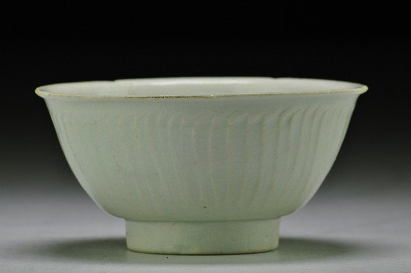 A QINGBAI BOWL.(SONG DYNASTY): A rare chinese porcelain bowl of upright form with notched rim,the interior with floral and wave designs in the yue style, the exterior with vertical petals,all under a pale blue glaze.3 1/4'' H 6 1/4