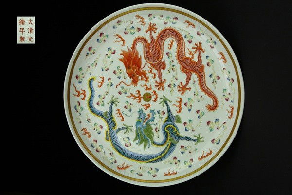 A FAMILLE-ROSE DRAGON DISH.(MARK AND PERIOD OF GUAN: the interior painted with a pair of five -clawed dragons contesting a flaming pearl admist flame and cloud scrolls,the exteriors similary decorated ,six character mark on base. 2 1/4'' H 14 3/4''Diam