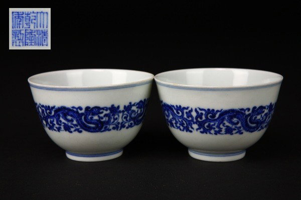 A PAIR OF BLUE AND WHITE CUPS.(MARK AND PERIOD OF : each finely painted around the exterior with the dragons and lotus scroll,six character mark on base. This lot was sold on Christies New York
